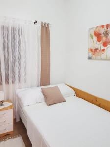 萨利Holiday Home Nada的一间卧室配有一张带白色床单的床和一扇窗户。