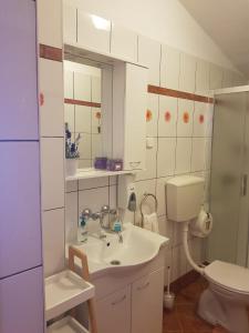 萨利Holiday Home Nada的一间带水槽、卫生间和镜子的浴室