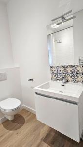 绍莱Appartement Le Porto的白色的浴室设有卫生间和水槽。