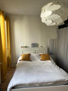 巴黎Beautiful & Spacious 3BD Family Home w Terrace的卧室配有一张大白色的床和一个大吊灯