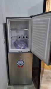 拉各斯Pentagon Court Phase 1 Apartment Ikota的一台小冰箱,其门在房间内打开