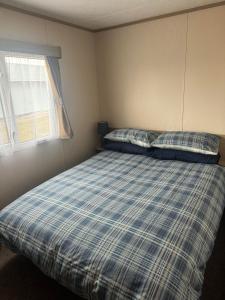 洛西茅斯Highway的一间卧室配有带两个枕头的床和窗户
