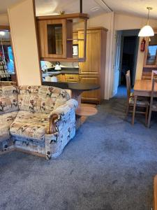 LlangristiolusHideout caravan的客厅配有沙发和桌子