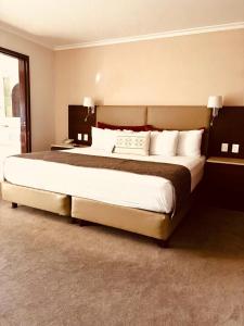瓜达拉哈拉Hotel Guadalajara Plaza Ejecutivo的卧室配有带白色枕头的大床