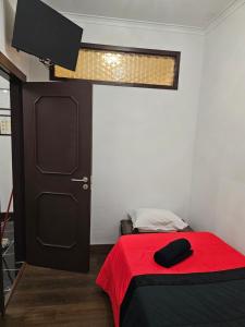 里奥廷托雷斯公寓的一间卧室配有一张带红色毯子和门的床