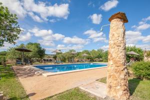 桑坦伊Finca Son Marimon的一个带石头柱子的庭院内的游泳池