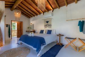 托兰克索Villa Mediterrâneo Trancoso的一间卧室配有一张带蓝色棉被的床