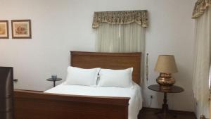 坎波斯杜若尔当瑞士中心公寓酒店的一间卧室配有一张带白色床单和一盏灯的床。