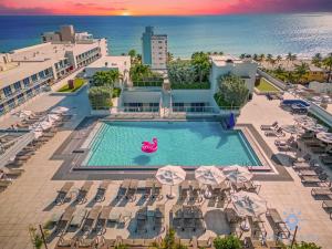 好莱坞Rooftop Pool - Hot Tub - Gym - Near Beach的享有带椅子和遮阳伞的游泳池的上方景致