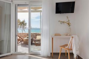 MytakasMytakas Houses的客房设有滑动玻璃门,享有海景。