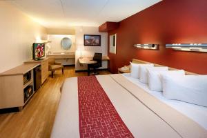 乔利埃特芝加哥乔利埃特红屋顶酒店的酒店客房设有一张大床和一张书桌。
