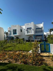 Ras ElhekmaTwin house 4 Bedrooms mountian view Ras Elhekma的前面有蓝色椅子的大白色房子