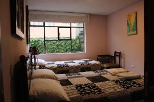 基多Casa de Tulia的带窗户的客房内的两张床