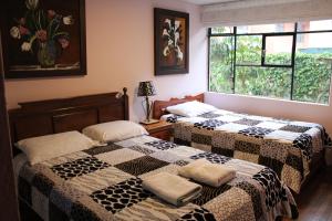 基多Casa de Tulia的两张床位于带窗户的房间内