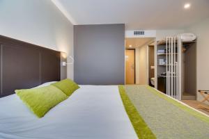 圣迪济耶圣迪济耶不瑞特酒店的卧室配有一张带绿色枕头的大型白色床