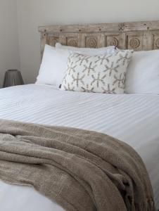 巴特曼斯贝亚拉伦汽车旅舍 的一张带枕头的白色床和毯子