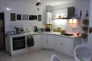 苏塞Dar Sarra的白色的厨房配有白色橱柜和电器