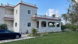伊斯梅利亚4-BRS Entire FarmHouse in Ismailia lGreen Paradise的前面有停车位的房子