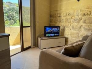 Għajn il-KbiraThe Nest Siekel Townhouse的客厅配有一张桌子,电视