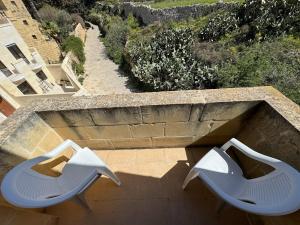 Għajn il-KbiraThe Nest Siekel Townhouse的阳台顶部设有两把白色椅子