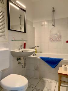 柏林威尔玛之家酒店的浴室配有盥洗盆、卫生间和浴缸。