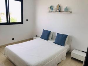 特马拉My Cosy Place Rabat - Maison harhoura vue mer的卧室配有带蓝色枕头的大型白色床