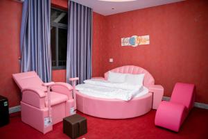 Ðịnh HòaThành Phố Mới Hotel的粉红色的卧室,配有一张床和两把椅子