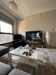 沙迦sharja 1103的客厅配有电视和白色咖啡桌。