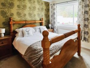 格伦芬南Torr Caladh的一间卧室设有一张木床和一个窗户。