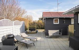 博恩瑟3 Bedroom Amazing Home In Bogense的一个带椅子和烧烤架的庭院