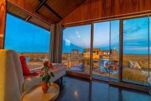 普诺KAY PACHA LODGE lago titicaca All Inclusive的客厅设有美景大窗户