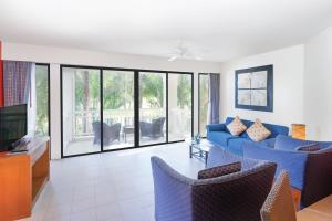 邦涛海滩Homm Suites Laguna的客厅配有蓝色的沙发和椅子