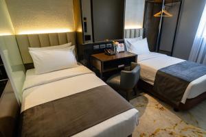 宿务Amber Hotel - Cebu的酒店客房配有两张床和一张书桌