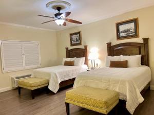 提华纳凯撒酒店的一间卧室配有两张床和吊扇