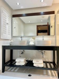 提华纳凯撒酒店的一间带两个盥洗盆和大镜子的浴室