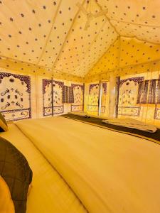 斋沙默尔Best Desert Camp In Jaisalmer Red Velvet的大房间,帐篷内有一张床