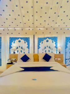 斋沙默尔Best Desert Camp In Jaisalmer Red Velvet的一间卧室设有一张大床,拥有蓝色和白色的墙壁