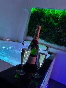 巴尔Beau gîte avec jacuzzi的一瓶香槟和一张桌子上的两杯酒