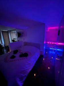 巴尔Beau gîte avec jacuzzi的一间卧室配有一张紫色灯床