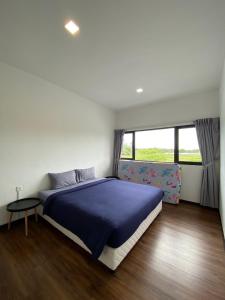 SematanRTS - ROXY Townhouse Sematan - Private - UPPER UNIT的一间卧室设有蓝色的床和窗户。