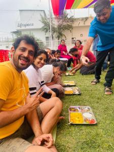 瑞诗凯诗Lifespace Rishikesh- Hotel, Hostel, Cowork, Cafe的一群坐在草地上吃食物的人