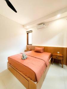 斯勒曼Villa Kamar Tamu Madurejo的一间卧室,在房间内配有一张大橙色的床
