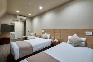 东京东京神保町芬迪别墅酒店的酒店客房设有两张床和一台平面电视。