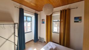 曼泰加什阿卡达斯达维拉公寓的一间卧室设有2扇窗户和蓝色窗帘