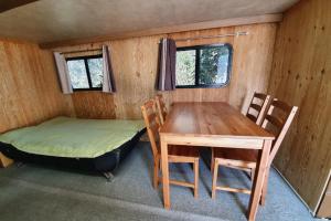 扶安Byeonsan Auto Camping的客房设有桌子、床和桌椅。