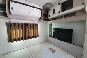 扶安Byeonsan Auto Camping的小型客厅配有电视和平面电视。