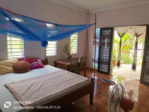暹粒Phonluer Angkor Homestay,的一间卧室配有一张蓝色天蓬床