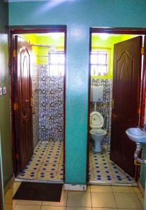 ThikaS & A APARTMENTS的浴室设有两扇门、卫生间和水槽。