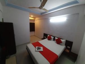艾哈迈达巴德hotel royal night的一间卧室配有红色和白色枕头的床