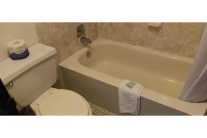 WashburnScotwood Motel by OYO Washburn ND的浴室配有白色卫生间和浴缸。
